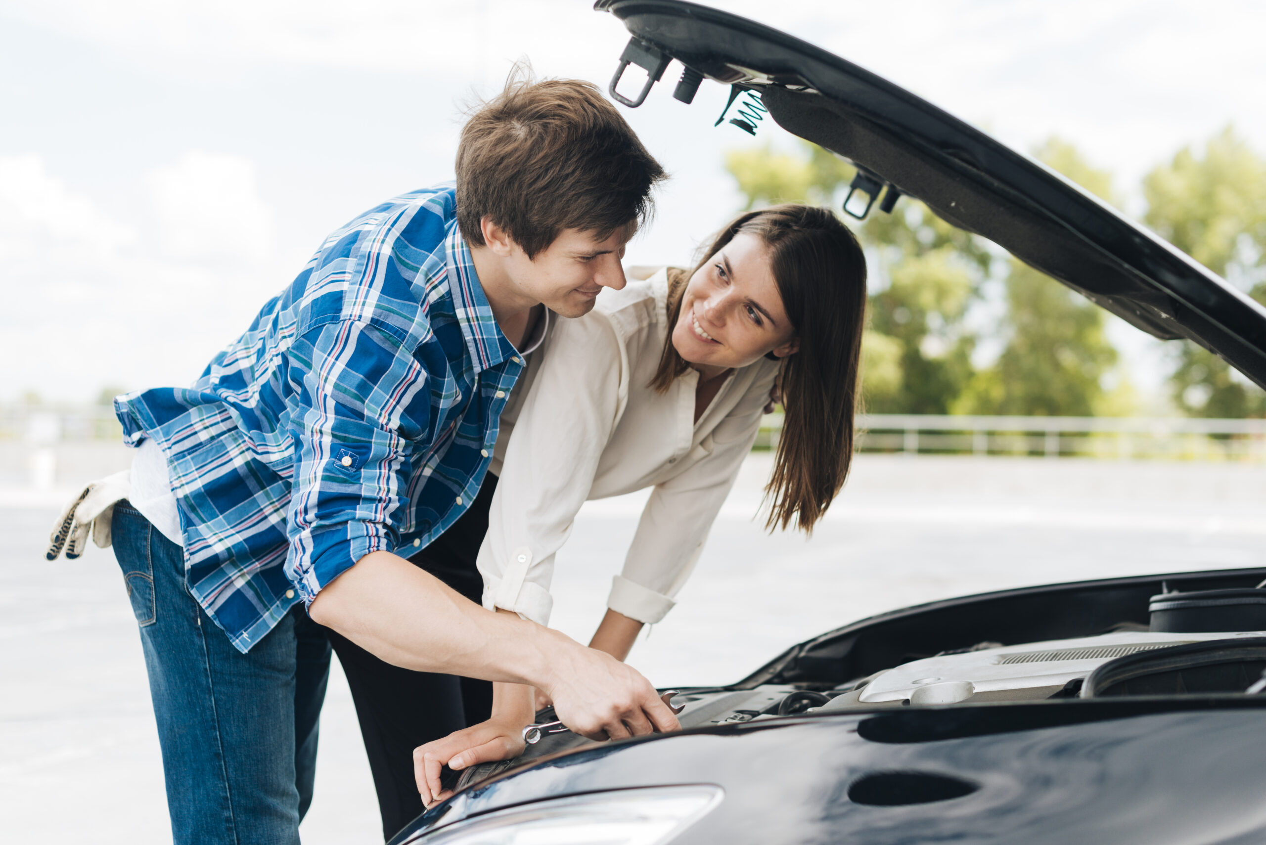 man-helps-woman-fix-her-car